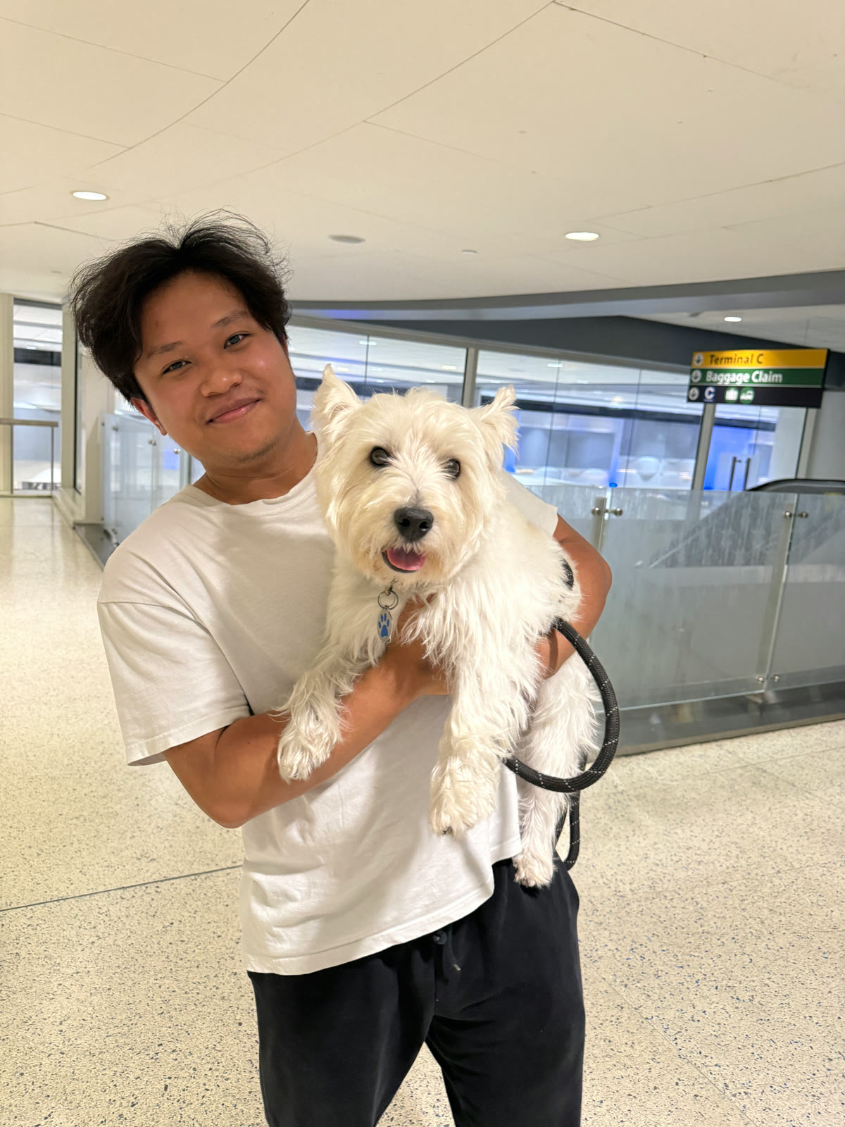 Erick holding Nunu, a white West Highland Terrier